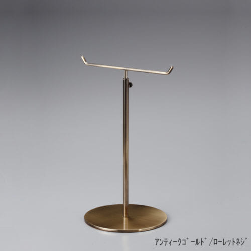 ●商品名:アクセサリースタンド-M ローレットネジ仕様 ●表面処理:金具部 アンディークゴールドメッキ(AG) ●寸法:高さ290~465mm ●ヘッド部:T字型 ●ヘッド:上下可動式(伸縮式) ●材質:スチール・木製(ベース) ●特長:特長:シンプルで汎用性のある金具部分に、木製ベースを組み合わせ、落ち着きのある存在感と高級感を演出できるツールとし製造しております。 ●生産国:日本(タヤ自社工場)