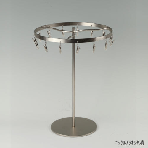 ●商品名:チーフ・ハンカチスタンド 回転式 ●表面処理:ニッケルツヤ消(NI-M)仕上 ●寸法:高さ300mm 上部回転リング直径240mm ●上部回転式リング:クリップ15個付 ●材質:スチール ●特長:百貨店様では棚板高さのスパンが30cm強の設定が多いと教えてもらい、では「高さ30cmのスペースにフィットするチーフツリーを作ろう」ということで高さ30cmのチーフツリーを製造しました。また、クリップの先端には塩ビのキャップを装着し、展示商品を傷つけにくい仕上がりになっています。 ●生産国:日本(タヤ自社工場)
