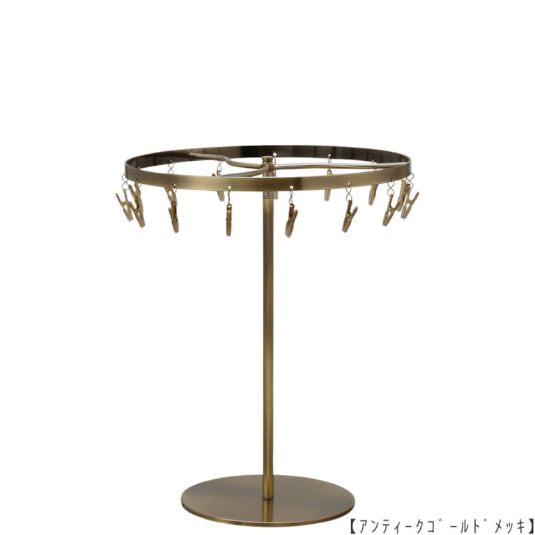 ●商品名:チーフ・ハンカチスタンド 回転式
●表面処理:アンティークゴールド(AG)仕上
●寸法:高さ300mm 上部回転リング直径240mm
●上部回転式リング:クリップ15個付
●材質:スチール
●特長:百貨店様では棚板高さのスパンが30cm強の設定が多いと教えてもらい、
では「高さ30cmのスペースにフィットするチーフツリーを作ろう」ということで高さ30cmのチーフツリーを製造しました。
また、クリップの先端には塩ビのキャップを装着し、展示商品を傷つけにくい仕上がりになっています。
●生産国:日本(タヤ自社工場)