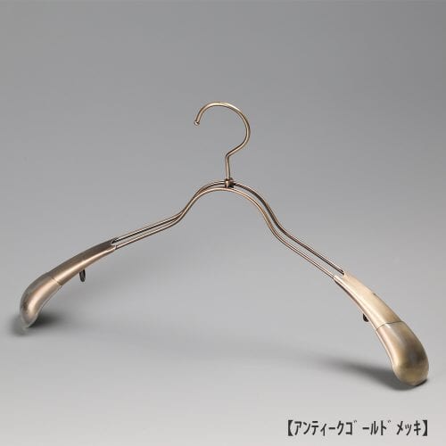 ●ハンガー正面画像 TSW-1357 アンティークゴールドメッキ(AG)仕上 ●メンズサイズ ●アウター・ジャケット・コート用 ●スチール製 ●湾曲型 ●フック回転式 ●ハンガーの肩先についたビニールキャップ付肩カバーにより、洋服の形を崩すこと無くきれいに優しく掛けることができます。また、肩先のキャップは衣類の滑り落ち防止効果も兼ね備えています。 ●意匠権所有商品 ●日本製