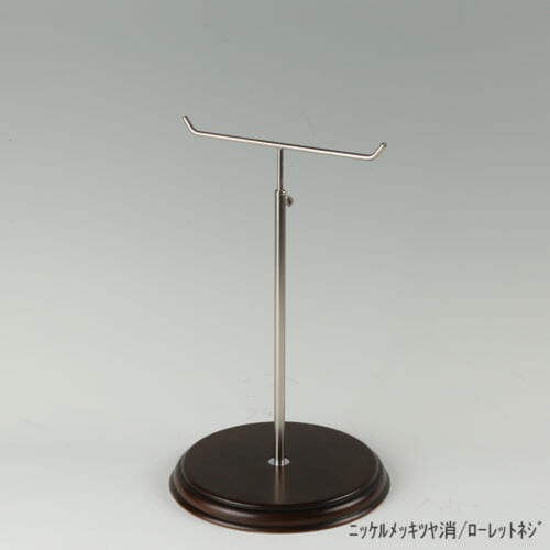 ●商品名:アクセサリースタンド-M ローレットネジ・木製ベース仕様 ●表面処理:金具部 ニッケルツヤ消(NI-M)/木部 茶染め ●寸法:高さ305~480mm ●ヘッド部:T字型 ●ヘッド:上下可動式(伸縮式) ●材質:スチール・木製(ベース) ●特長:特長:シンプルで汎用性のある金具部分に、木製ベースを組み合わせ、落ち着きのある存在感と高級感を演出できるツールとし製造しております。 ●生産国:日本(タヤ自社工場)