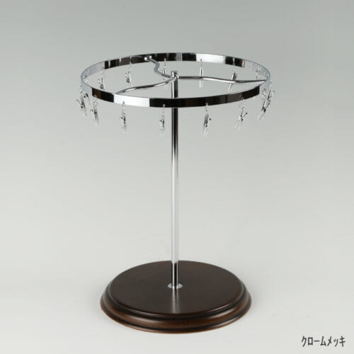 ●商品名:チーフ・ハンカチスタンド回転式 木製ベース仕様 ●表面処理:クロームメッキ(Cr)仕上 ●寸法:高さ315mm 上部回転リング直径240mm ●上部回転式リング:クリップ15個付 ●材質:スチール ●特長:百貨店様では棚板高さのスパンが30cm強の設定が多いと教えてもらい、では「高さ30cmのスペースにフィットするチーフツリーを作ろう」ということで高さ30cmのチーフツリーを製造しました。また、クリップの先端には塩ビのキャップを装着し、展示商品を傷つけにくい仕上がりになっています。さらに、木製のベースを組み合わせることで、落ち着きのある存在感と高級感を演出できます。 ●生産国:日本(タヤ自社工場)