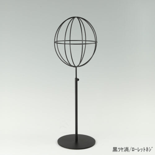 ●商品名:帽子スタンド 球体型-M ローレットネジ仕様 ●表面処理:黒ツヤ消(BK-M)仕上 ●寸法:高さ450~560mm ●ヘッド部:ワイヤー製ラグビーボール型球体ヘッド ●ヘッド:上下可動式(伸縮式) ●材質:スチール ●特長:ワイヤーフレームの抜け感が、シンプルでおしゃれな空間を演出します。 ●生産国:日本(タヤ自社工場)