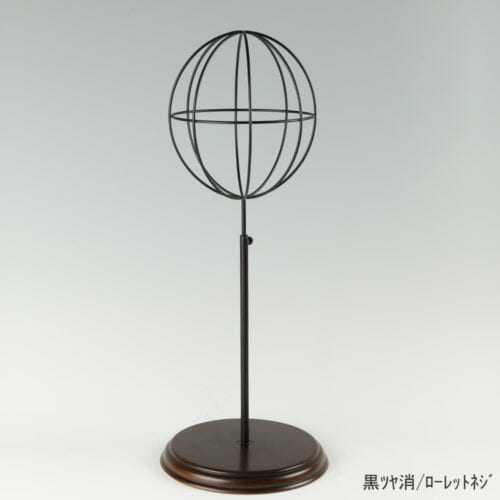 ●商品名:帽子スタンド 球体型-M ローレットネジ・木製ベース仕様 ●表面処理:黒ツヤ消(BK-M)仕上 ●寸法:高さ465~575mm ●ヘッド部:ワイヤー製ラグビーボール型球体ヘッド ●ヘッド:上下可動式(伸縮式) ●材質:スチール・木製(ベース) ●特長:抜け感がおしゃれなワイヤーヘッドに木製ベースを組み合わせ、落ち着きのある存在感と高級感を演出するツール ●生産国:日本(タヤ自社工場)