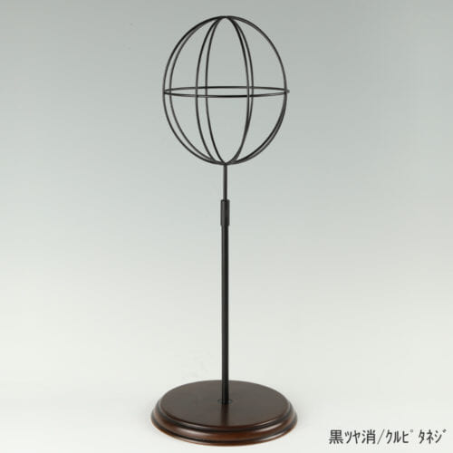 ●商品名:帽子スタンド 球体型-M ローレットネジ・木製ベース仕様 ●表面処理:黒ツヤ消(BK-M)仕上 ●寸法:高さ495~605mm ●ヘッド部:ワイヤー製ラグビーボール型球体ヘッド ●ヘッド:上下可動式(伸縮式) ●材質:スチール・木製(ベース) ●特長:抜け感がおしゃれなワイヤーヘッドに木製ベースを組み合わせ、落ち着きのある存在感と高級感を演出するツール ●生産国:日本(タヤ自社工場)