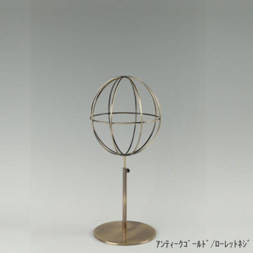 ●商品名:帽子スタンド 球体型-S ローレットネジ仕様 ●表面処理:アンティークゴールドメッキ(AG)仕上 ●寸法:高さ395~485mm ●ヘッド部:ワイヤー製ラグビーボール型球体ヘッド ●ヘッド:上下可動式(伸縮式) ●材質:スチール ●特長:ワイヤーフレームの抜け感が、シンプルでおしゃれな空間を演出します。 ●生産国:日本(タヤ自社工場)