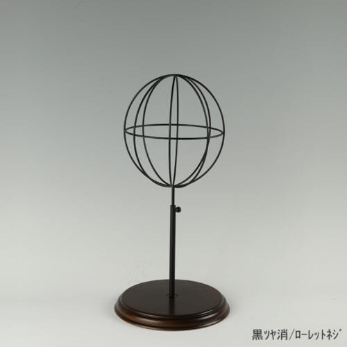 ●商品名:帽子スタンド 球体型-S ローレットネジ・木製ベース仕様 ●表面処理:黒ツヤ消(BK-M)仕上 ●寸法:高さ410~500mm ●ヘッド部:ワイヤー製ラグビーボール型球体ヘッド ●ヘッド:上下可動式(伸縮式) ●材質:スチール・木製(ベース) ●特長:抜け感がおしゃれなワイヤーヘッドに木製ベースを組み合わせ、落ち着きのある存在感と高級感を演出するツール ●生産国:日本(タヤ自社工場)
