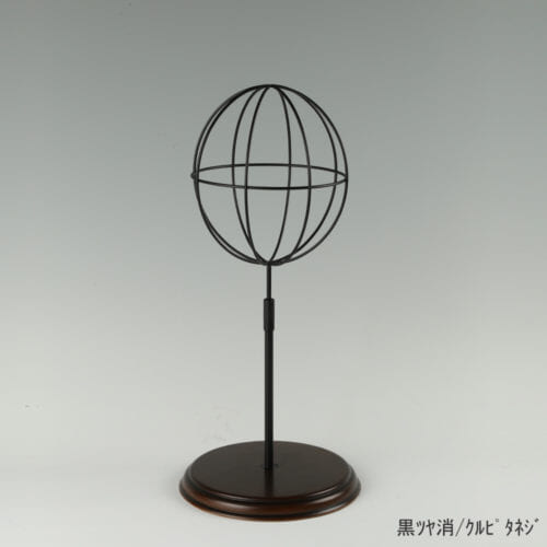 ●商品名:帽子スタンド 球体型-S ローレットネジ・木製ベース仕様 ●表面処理:黒ツヤ消(BK-M)仕上 ●寸法:高さ440~530mm ●ヘッド部:ワイヤー製ラグビーボール型球体ヘッド ●ヘッド:上下可動式(伸縮式) ●材質:スチール・木製(ベース) ●特長:抜け感がおしゃれなワイヤーヘッドに木製ベースを組み合わせ、落ち着きのある存在感と高級感を演出するツール ●生産国:日本(タヤ自社工場)