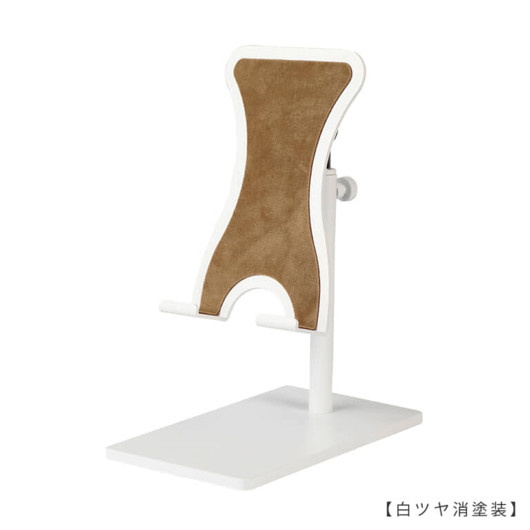 ●商品名:スマホスタンド 小
●型番:SPS-01-SS-MO10-WH-M
●表面処理:白ツヤ消塗装
●素材:鉄
●特長:素材である鉄の特徴を活かし、「スタイリッシュ」「省スペース」「機能性」を兼ね備えたデザインを目指し設計。ベース(鉄板の台座)には必要最低限の面積と重量を持たせ安定感を確保。スマートフォンを置いたり取ったりする際にスタンドごとスマートフォンを持ちあげてしまわないよう、ヘッド部天板両サイドには緩やかな曲線のクボミをつけ指がかかりにくくなるよう配慮したデザイン。
ベースの裏面とスマートフォンが接する天板部分にはそれぞれ形状に合わせたフェルトのシートが貼られ、デスクやスマートフォンに傷がつきにくい仕様。
ヘッド部は「角度」「高さ」の調整が可能、「回転」させることもできます。スマートフォンスタンドを使用する目的に合わせ、お好みの「角度」や「高さ」「向き」に調整し快適なスマートフォンタイムをお楽しみください。
また、ケーブルをスマホに差したままスタンドが使用できる仕様となっていますので充電しながらのご使用、ヘッドホンを使用しながらのご使用も可能です。
●ヘッド上下調節・向きの調整: ローレットネジを締めることにより固定します(指でネジを回せる仕様です)。
●ヘッド角度調整: 力で角度調整ができるようになっています。お好みの力で角度が変わるように調整する際には同梱の六角レンチを使用してお好みの硬さに調整してください。
●日本製
●重量:約447g