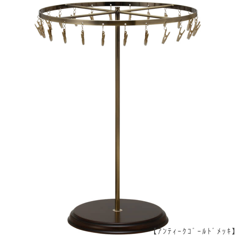 ●商品名:チーフ・ハンカチスタンド回転式 Lサイズ 木製ベース仕様
●表面処理:アンティークゴールド(AG)仕上
●寸法:高さ420mm 上部回転リング直径300mm
●上部回転式リング:クリップ24個付
●材質:スチール・
●特長:長さのある小物も吊り下げることができるように、高さを付けました。小物を吊るす円形部分は、見やすいように回転させることが可能です。
クリップの先端には塩ビのキャップを装着し、展示商品を傷つけにくい仕上がりになっています。さらに、木製のベースを組み合わせることで、落ち着きのある存在感と高級感を演出できます。
●生産国:日本(タヤ自社工場)