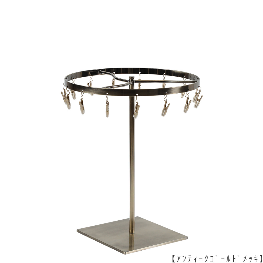 ●商品名:チーフ・ハンカチスタンド 回転式
●表面処理:アンティークゴールド(AG)仕上
●寸法:高さ300mm 上部回転リング直径240mm
●上部回転式リング:クリップ15個付
●材質:スチール
●特長:百貨店様では棚板高さのスパンが30cm強の設定が多いと教えてもらい、
では「高さ30cmのスペースにフィットするチーフツリーを作ろう」ということで高さ30cmのチーフツリーを製造しました。
また、クリップの先端には塩ビのキャップを装着し、展示商品を傷つけにくい仕上がりになっています。
●生産国:日本(タヤ自社工場)