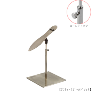 ●商品名：シューズスタンド片足用 ローレットネジ仕様
●表面処理：アンティークゴールド（ＡＧ）仕上
●寸法：高さ215～305ｍｍ
●ヘッド部：傾斜角度調整機能付。靴滑り落ち防止部材溶接留。
●ヘッド：上下可動式（伸縮式）
●材質：スチール
●特長：展示物である靴のデザインを際立たせる天板デザイン設計。
天板を足型状にすることにより、靴を乗せると天板が隠れるサイズで製造。
天板が見えなくなる事によりお客様の視線が展示物の靴に集中、靴のデザインが際立ちます。
●片足用スタンドである理由：両足分の靴をセットで展示しておくと、
靴を持って行かれてしまう可能性が高くなるとのお話を聞き、
通常品としては片足用のシューズスタンドをご用意しました。
●生産国：日本（タヤ自社工場）