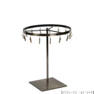 ●商品名:チーフ・ハンカチスタンド 回転式 
●表面処理:アンティークゴールドメッキ(AG)仕上
●寸法:高さ300mm 上部回転リング直径240mm 
●上部回転式リング:クリップ15個付
●材質:スチール
●特長:百貨店様では棚板高さのスパンが30cm強の設定が多いと教えてもらい、
では「高さ30cmのスペースにフィットするチーフツリーを作ろう」ということで高さ30cmのチーフツリーを製造しました。
また、クリップの先端には塩ビのキャップを装着し、展示商品を傷つけにくい仕上がりになっています。
●生産国:日本(タヤ自社工場)
※AGのみ先行リニューアル(別画像参照)