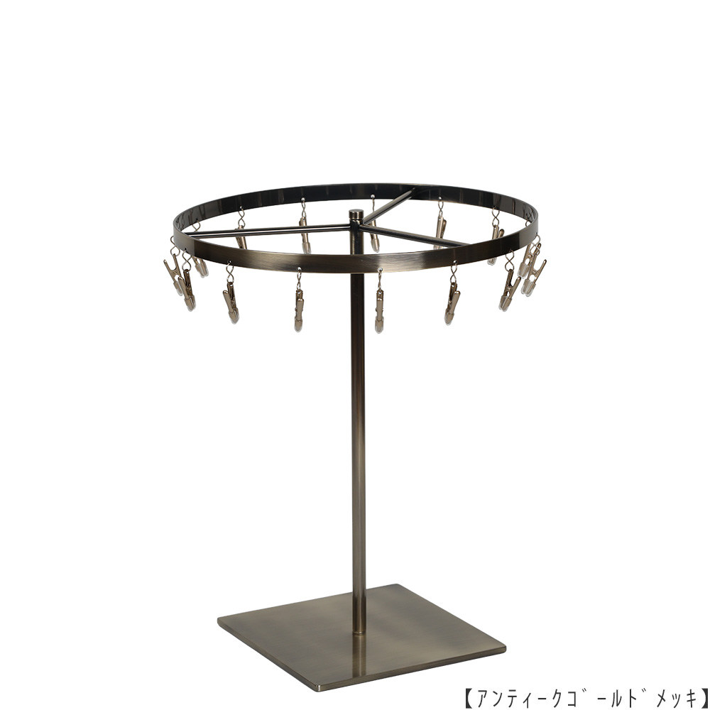 ●商品名:チーフ・ハンカチスタンド 回転式 
●表面処理:アンティークゴールドメッキ(AG)仕上
●寸法:高さ300mm 上部回転リング直径240mm 
●上部回転式リング:クリップ15個付
●材質:スチール
●特長:百貨店様では棚板高さのスパンが30cm強の設定が多いと教えてもらい、
では「高さ30cmのスペースにフィットするチーフツリーを作ろう」ということで高さ30cmのチーフツリーを製造しました。
また、クリップの先端には塩ビのキャップを装着し、展示商品を傷つけにくい仕上がりになっています。
●生産国:日本(タヤ自社工場)
※AGのみ先行リニューアル(別画像参照)